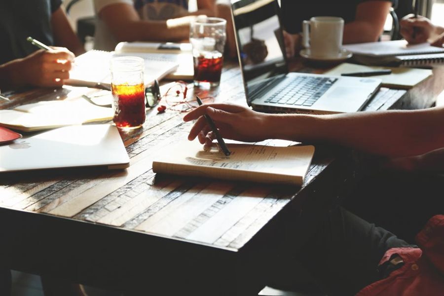 Planning notes, laptops and coffee on a shared working desk